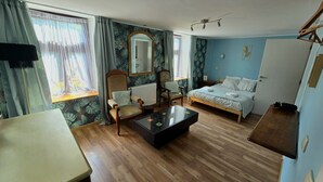 Une pièce comprenant un lit, une chaise, une table et un miroir.