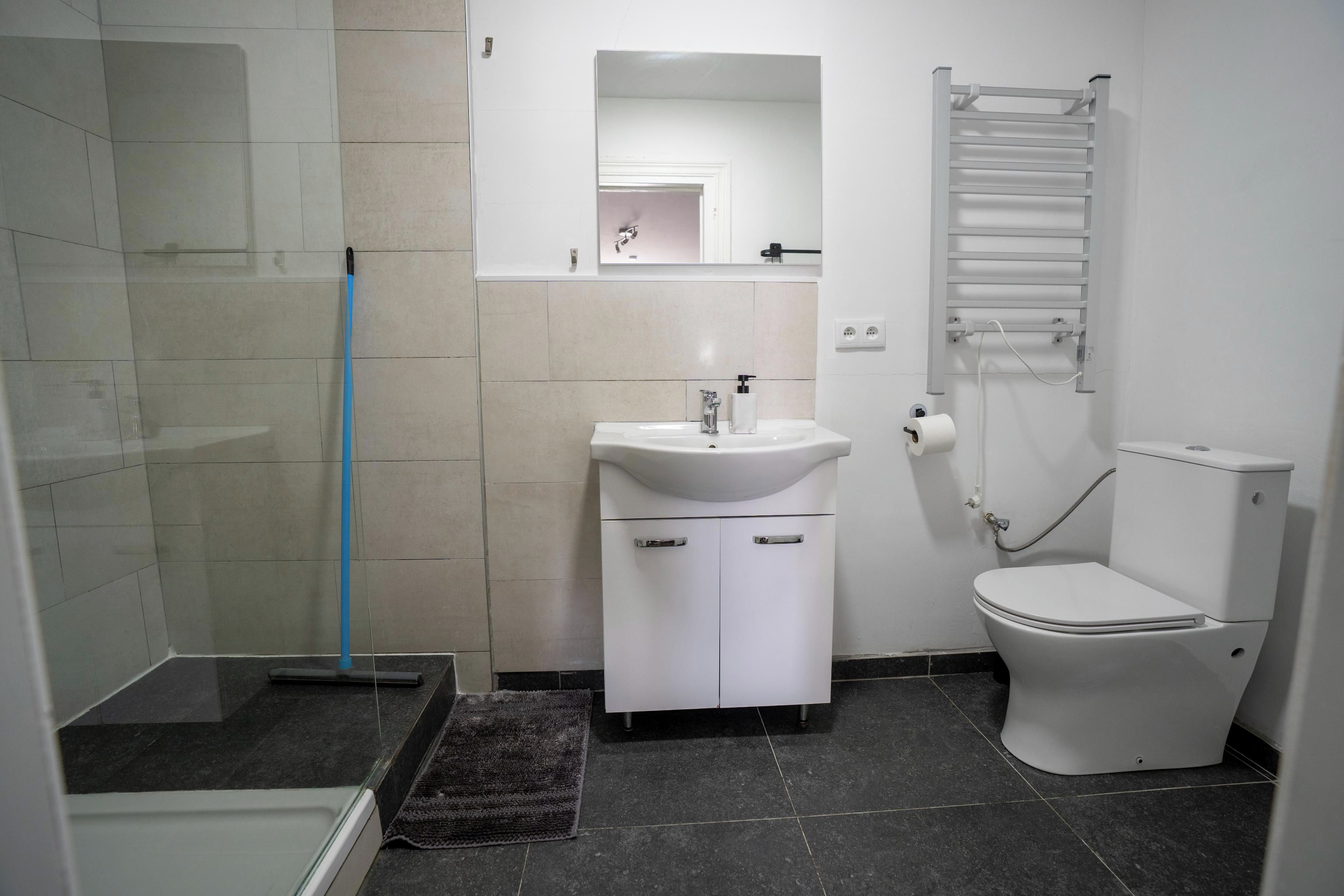Une salle de bain équipée d’une douche, d’un lavabo, de toilettes et d’un porte-serviettes.