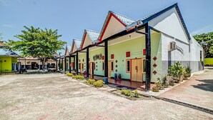 A row of modern, single-story buildings with a flat roof and a covered walkway. - Hotel O Anugrah (Kualuh Hulu)