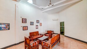 A spacious room with a wooden dining set and several framed artworks on the walls. - Hotel O Anugrah (Kualuh Hulu)