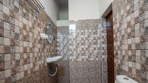 Ein Badezimmer mit einem weißen Waschbecken, einer Toilette und einer Duschkabine.