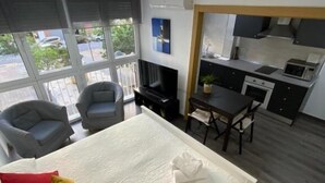 Una habitación de hotel moderna con una cama, un escritorio y una kitchenette.