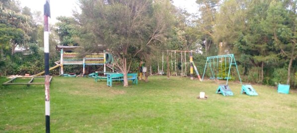A playground with various equipment such as swings, slides, and climbing structures.