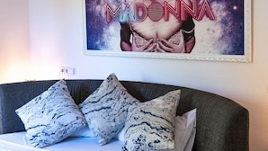 A bedroom with a bed, pillows, and a wall-mounted poster of Madonna. - Villa Sofía súper lujo (Valldemossa)