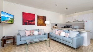 A modern living room with two sofas, a coffee table, and artwork on the wall.
