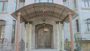 An ornate entrance with a curved archway, columns, and a chandelier. - Prestige Terrace Hotel (Bukhara)