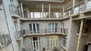 A multi-level courtyard with ornate balconies and a central seating area. - Prestige Terrace Hotel (Bukhara)