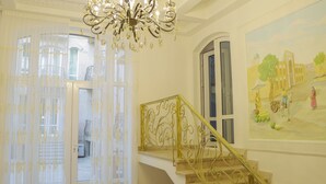 A staircase with ornate golden railings and a chandelier. - Prestige Terrace Hotel (Bukhara)