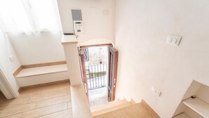 Una escalera conduce a un balcón con vistas al exterior.