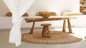 Ein Holztisch mit einer gewebten Matte, einer Zitronenschale und einem Kissen aus Bändern auf einer weißen Bank.