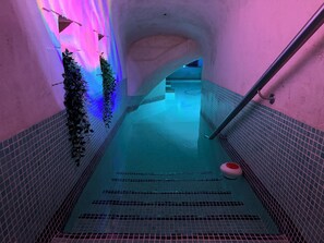 Ein schmales, gefliestes Pool-Areal mit einer Treppe, die nach unten führt.