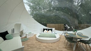A tented accommodation with a round bed, a dining table, and a telescope. - Au domaine du Pré Dieu (Crécy-sur-Serre)