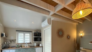 A compact living space with a kitchen, a washing machine, a sofa, and a dining area. - Au domaine du Pré Dieu (Crécy-sur-Serre)