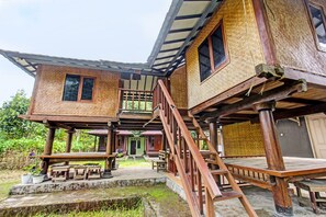 Ein traditionelles Holzhaus mit Balkon, Treppe und einer kleinen Veranda.