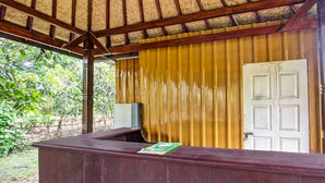 Un mostrador de recepción de madera con una puerta cerrada y una ventana con vistas a zonas verdes.