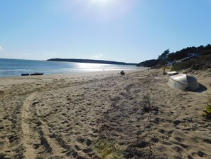 Une plage de sable avec des bateaux et un ciel dégagé.