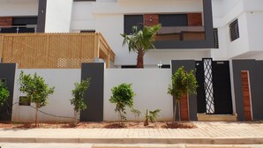 A modern two-story residential building with a flat roof, a balcony, and a gated entrance. - Villa Avec Piscine Privée à Saidia (Saïdia)
