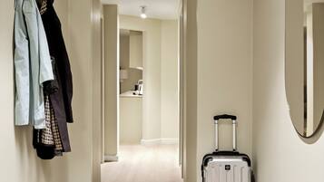 A hallway with a coat rack, a suitcase, and a pair of shoes.
