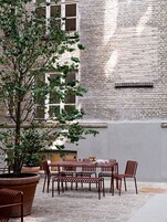An outdoor seating area with brick walls and a tree.