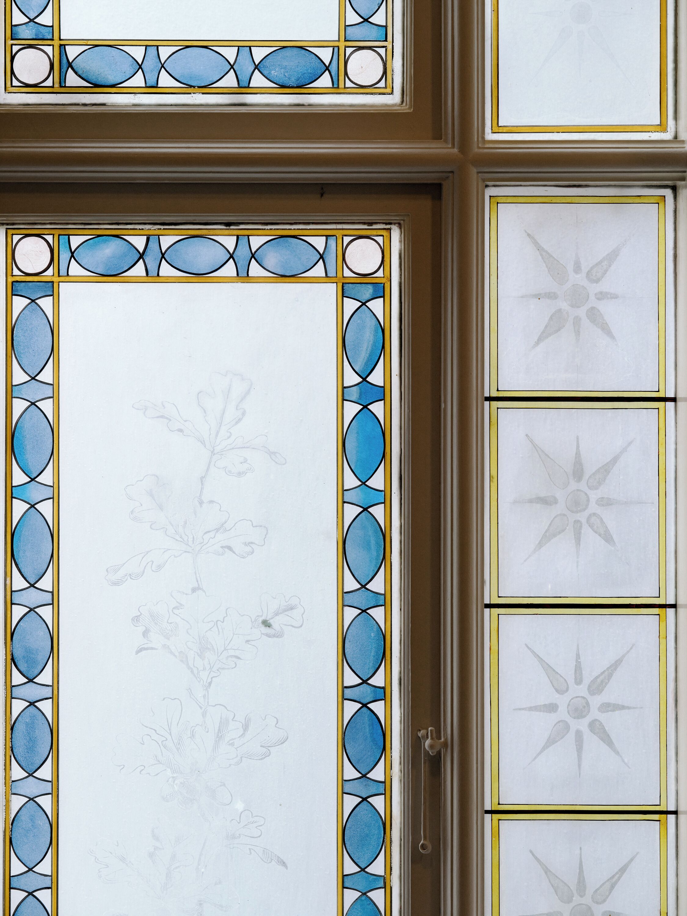 Et farvet glasvindue med blomstermotiver og geometriske mønstre.