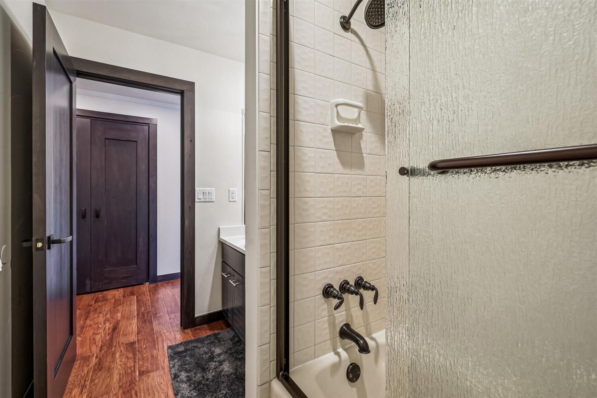 A bathroom with a shower, a toilet, and a sink.