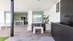 A modern kitchen with a bar area, a seating bench, and a sign indicating a home theater.