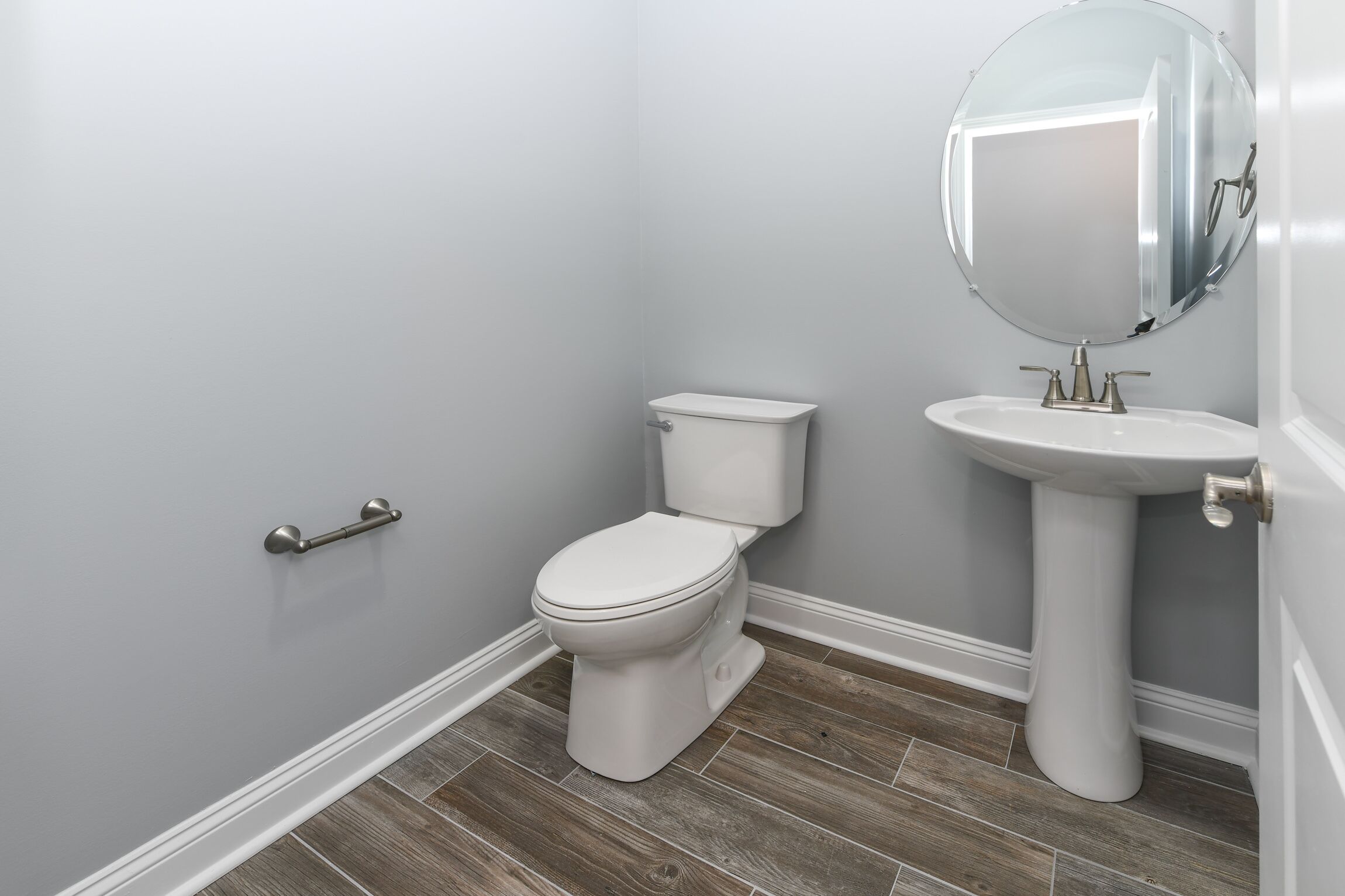 Et badeværelse med toilet, håndvask og spejl.