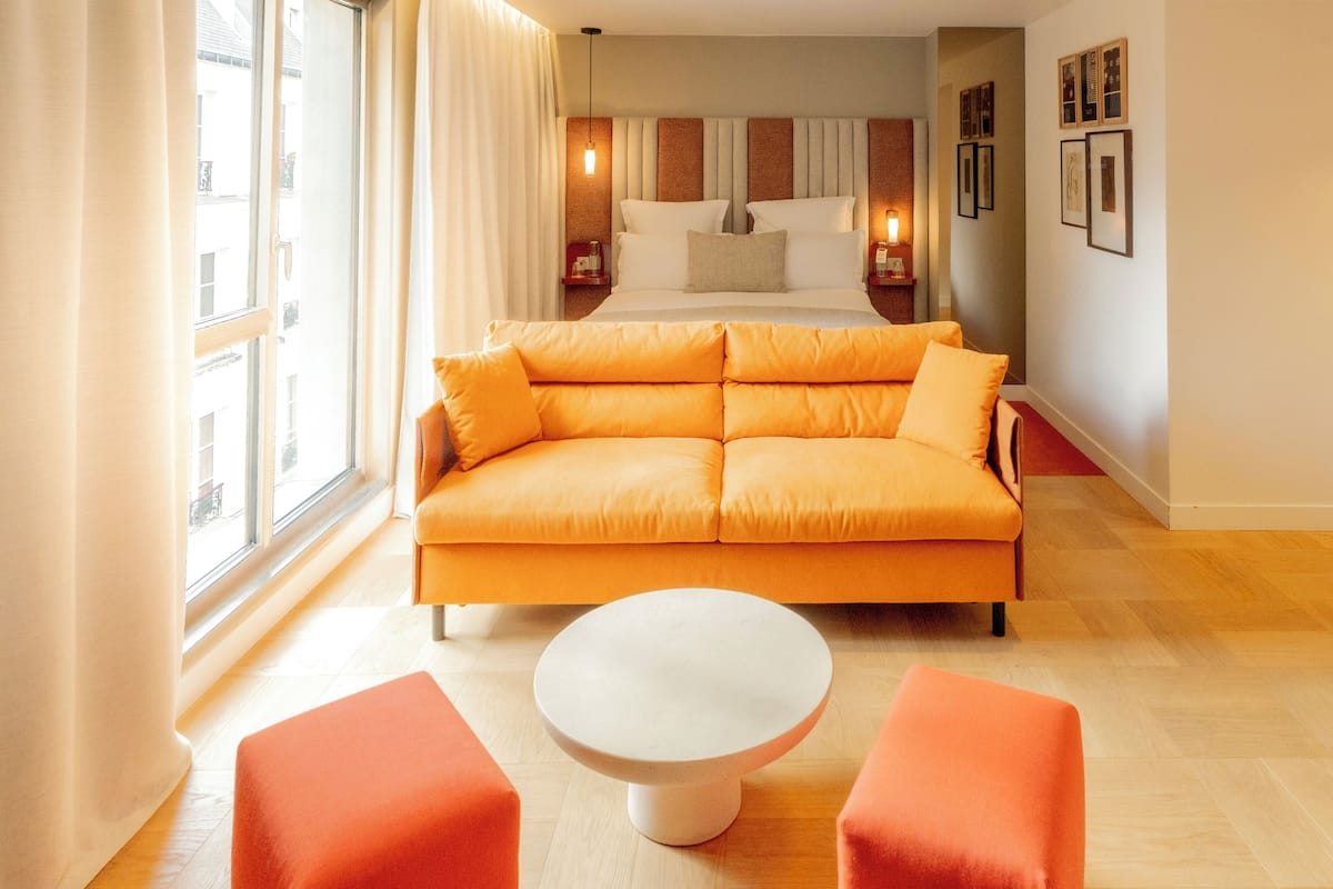 Un salon moderne avec un canapé, une table basse ronde et un coin repas.