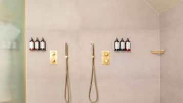 Un baño moderno con dos cabezales de ducha y un rociador de mano.