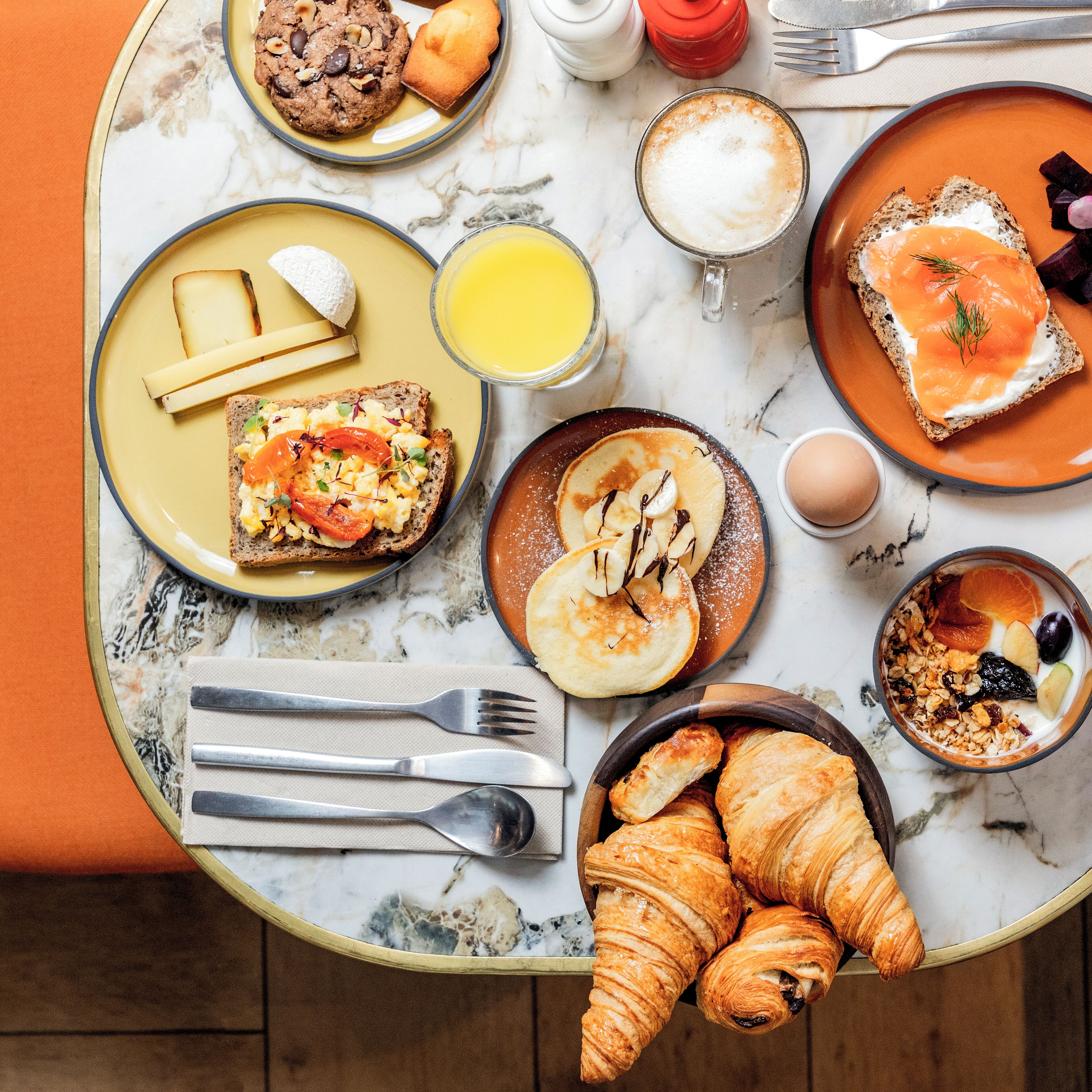 Une table de petit-déjeuner avec divers aliments et un croissant.