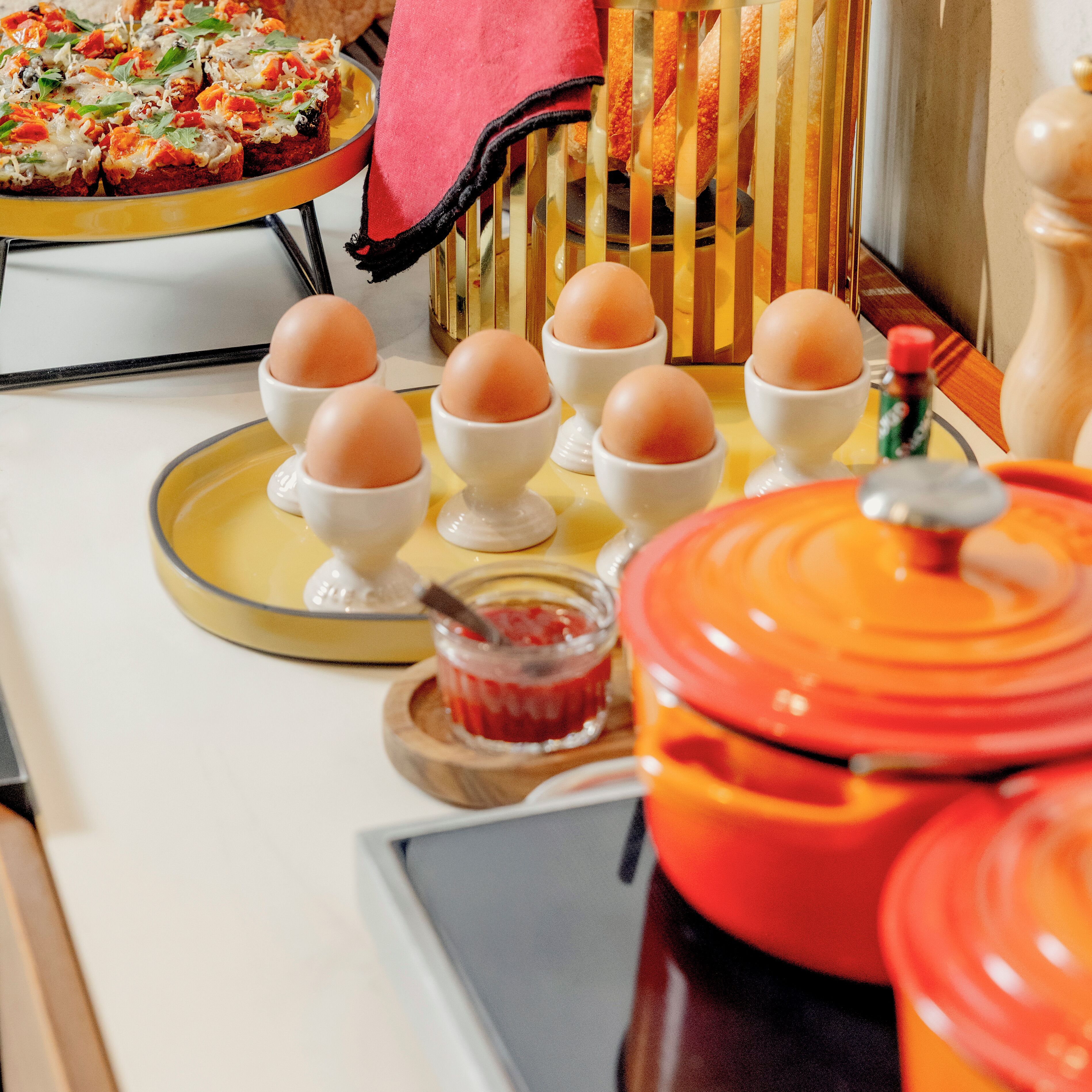 Un buffet de petit-déjeuner avec des œufs, des accompagnements et une pizza.