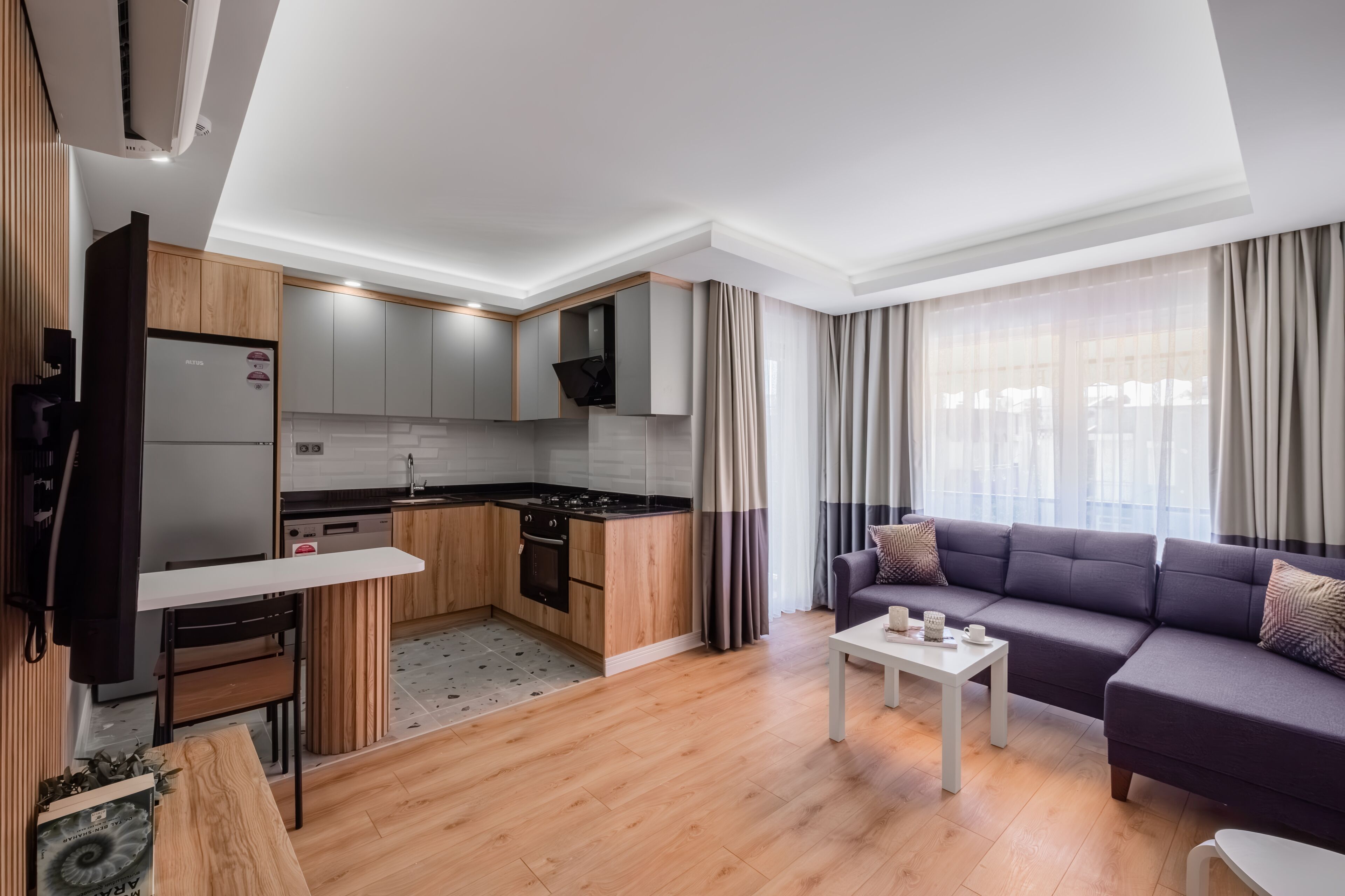 Un appartement moderne comprenant une cuisine, un coin repas et un salon.