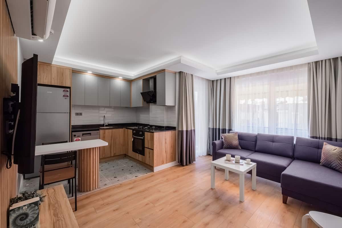 A modern apartment with a kitchen, dining area, and living room.