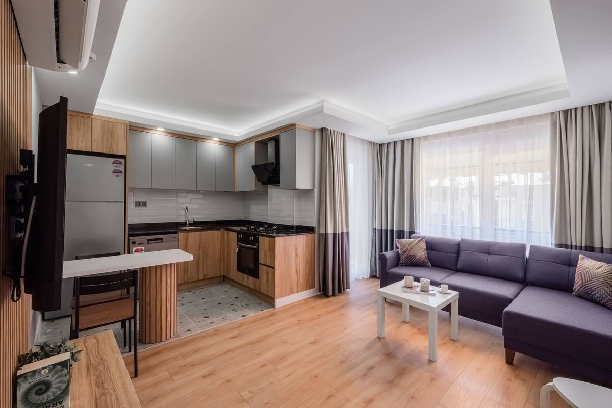 Um apartamento moderno com cozinha, sala de jantar e sala de estar.