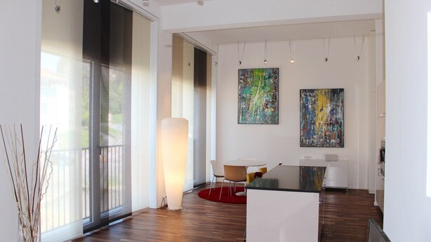 A modern art gallery with wooden floors, a large abstract painting, and a minimalist seating area. - Superb Loft In The Center Of Lausanne (Lausanne)