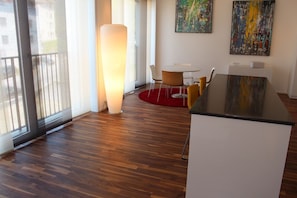 Um interior moderno com piso de madeira, uma escrivaninha branca e duas pinturas abstratas na parede.
