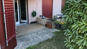 A courtyard with a sliding glass door, a small table, and a potted plant. - Large Studio Near Epfl And Lausanne City Center (Ecublens)