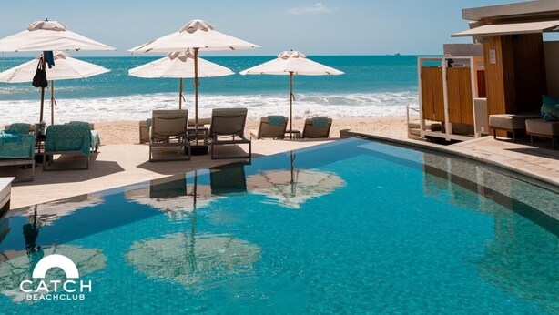 A poolside area with lounge chairs and umbrellas, a wooden deck, and a view of the ocean. - Perfect 2br Pool Villa In Residence Bangtao Beach4 (Tambon Choeng Thale)
