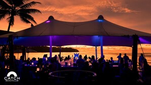 A beachside event with a large canopy, palm trees, and a sunset in the background. - Perfect 2br Pool Villa In Residence Bangtao Beach4 (Tambon Choeng Thale)