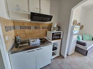 Enjoy cooking in this well-equipped kitchen with a stainless steel sink, range hood, and microwave oven.