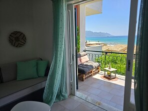 Enjoy the breathtaking sea and mountain views from this balcony with a comfortable seating area.