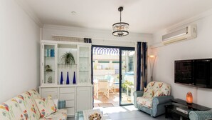A living room with a sofa, chairs, a coffee table, a television, and a glass cabinet with decorative items. - Playa Azul , Luxury Penthouse with spectacular roof terrace (Lomo Quiebre)
