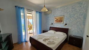 Un dormitorio con cama, escritorio, silla, sillón colgante y vistas al exterior.