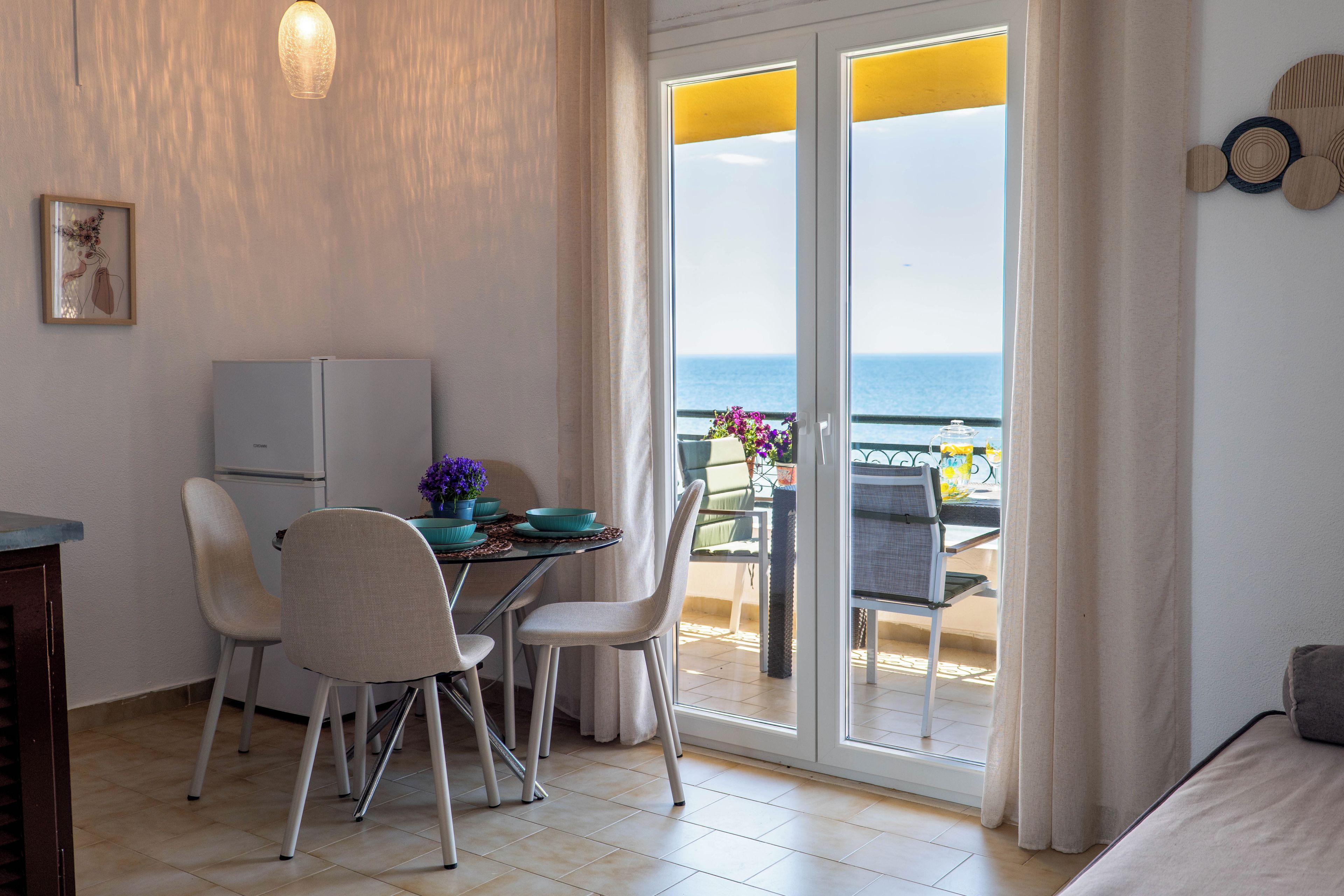 Une chambre dotée d’un coin repas, d’un lit et offrant une vue sur la mer.