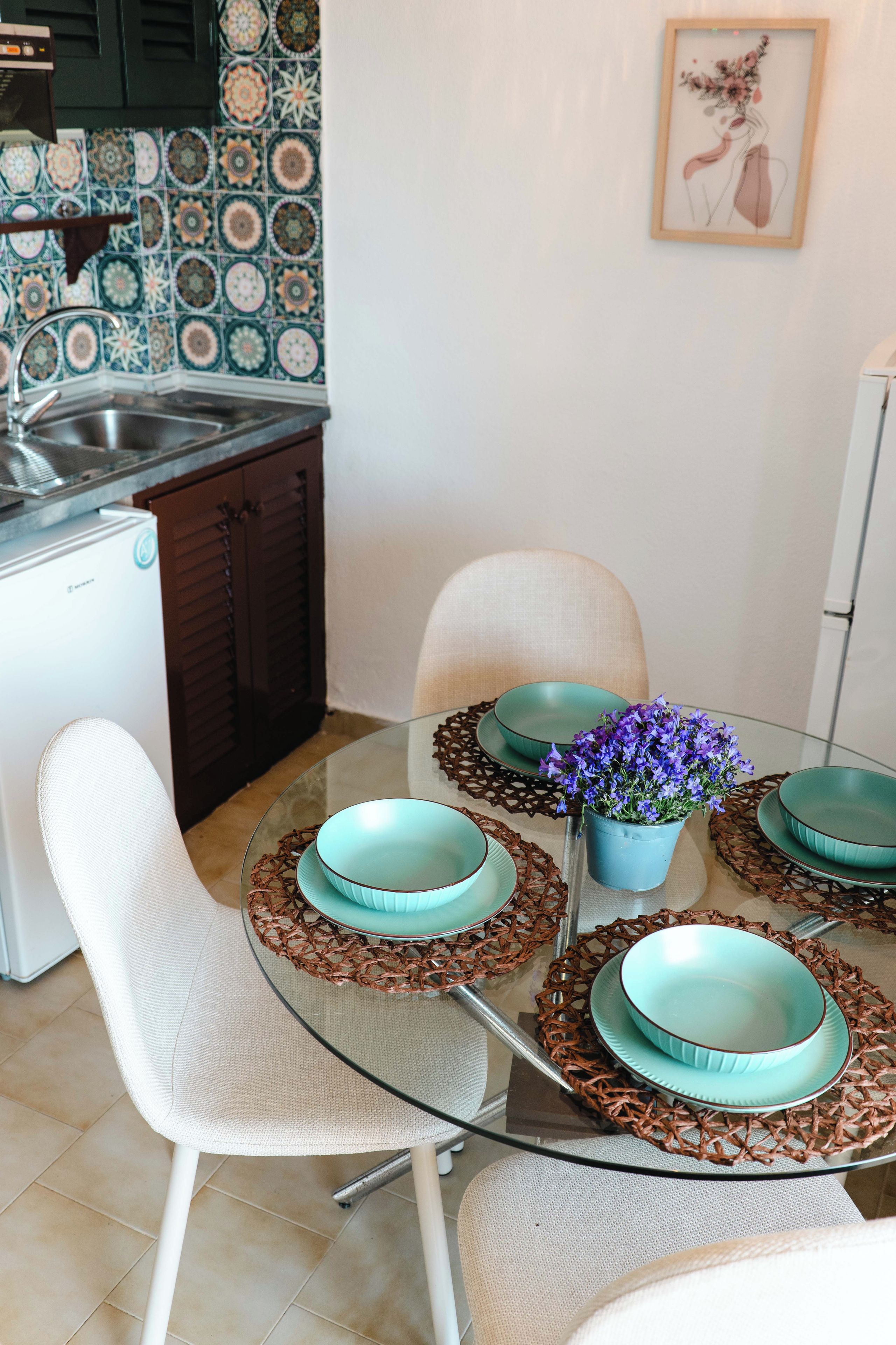 A modern kitchen with a tiled backsplash, a sink, cabinets, and a refrigerator.