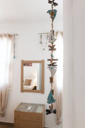 Een kamer met een bed, een kaptafel en een spiegel aan de muur.