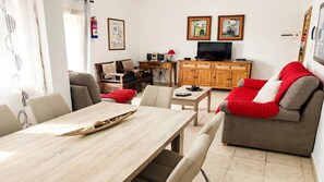 Un soggiorno moderno con un divano, un tavolo da pranzo e una televisione.
