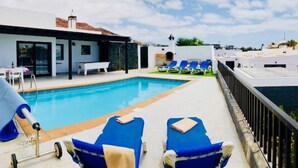 A rooftop pool area with blue lounge chairs and a small pool. - Villa Neptuno with private pool, sea view, Smart-TV & free Wifi (Playa Blanca)