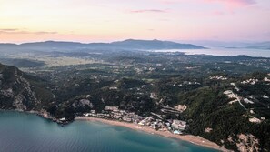 Vista aérea de una zona costera con playa, edificios residenciales y un gran hotel.
