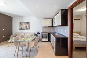 Una cocina moderna con zona de comedor, un sofá y un cuadro en la pared.